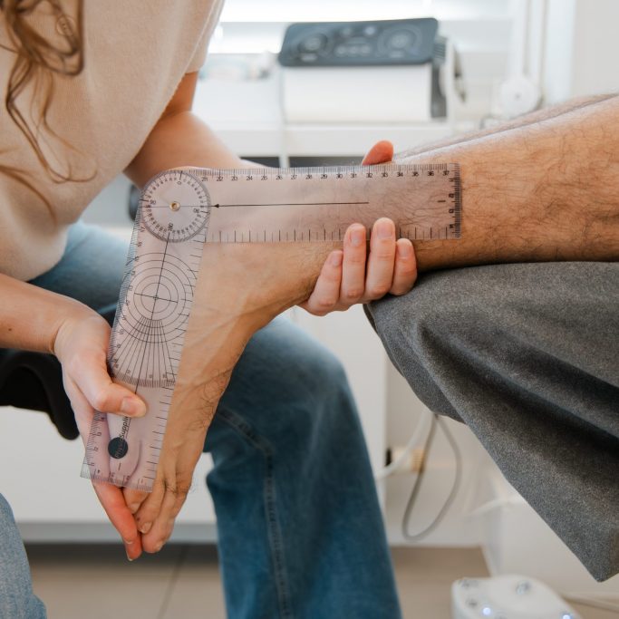 Podoloog gebruikt een goniometer om de range of motion te meten van het enkelgewricht.